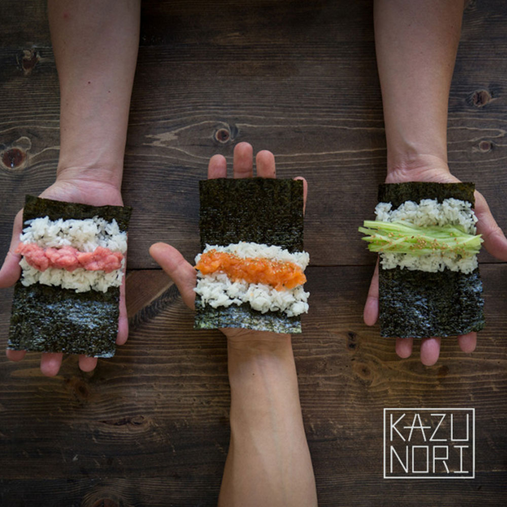 3 hands holding hand rolls